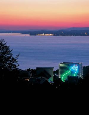 Foto: KUB - Kunsthaus Bregenz mit Lichtinstallation und im Hintergrund die Lindauer Insel